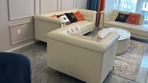 Ein modernes Wohnzimmer mit zwei Sofas, einem Couchtisch und einem blauen Sessel.