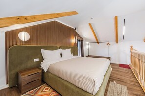 Une chambre à coucher avec un lit, des tables de chevet, une lampe suspendue et un plafond en bois.