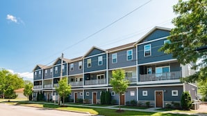 A multi-story residential building with balconies, a flat roof, and a well-maintained lawn. - Sage Solace Studio | Near Downtown & Beaches (Traverse City)