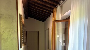 Passadís amb sostre de fusta, un radiador i una porta al final.