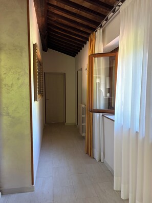 A hallway with a wooden ceiling, a radiator, and a door at the end. - Villetta immersa nel verde dell'Umbria (Umbria)