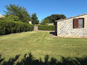 A stone building with a window and a door, surrounded by a well-maintained lawn and hedges. - Villetta immersa nel verde dell'Umbria (Umbria)