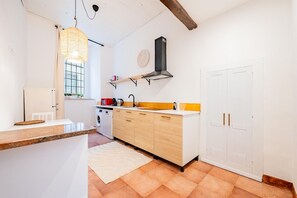 A compact kitchen with a washing machine, a sink, and a hanging light fixture. - Apartment house "Iulia"- Pinerolo (historic center) (Pinerolo)