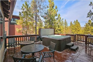 A wooden deck with a hot tub, outdoor seating, and a view of trees. - Peek-A-Boo Lake View, Dog Yard, Near Village (Big Bear Lake)