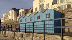 A coastal building with a blue facade, a wooden deck, and a metal railing. - Vendée getaway: Mobil home _ Commequiers (Commequiers)