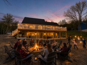 A house with a deck, outdoor seating, and a fire pit.