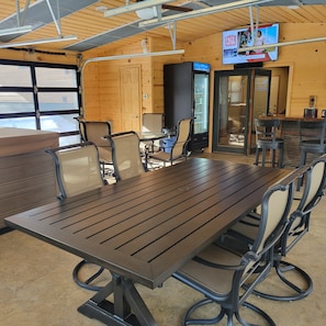 A conference room with a long table, chairs, a television, and a door. - Spacious Hillside Cabin Near Slopes (Lead)