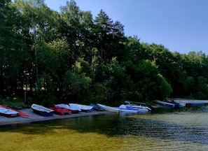 A calm river with boats docked along the shore, surrounded by dense trees. - Lakeside Holiday Villa, Private Garden (Szczecinek)