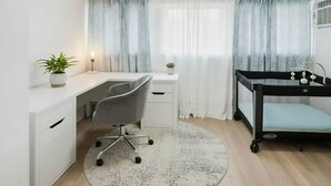 A room with a desk, chair, bunk bed, and a round rug.