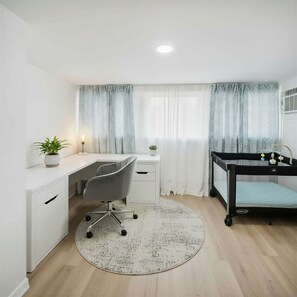 A room with a desk, chair, bunk bed, and a round rug.