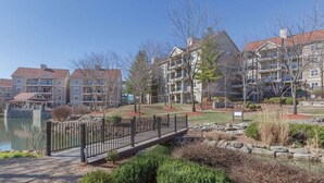 A residential area with multi-story buildings, a bridge, and a body of water. - Relaxing Branson Getaway with Pools & Spacious 2BR Vacation Suite (Branson)