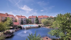 Un hotel con piscina, fuente y vistas de los edificios circundantes.