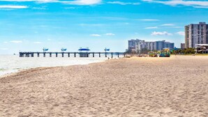A beach with a pier, sandy shore, and high-rise buildings in the background. - Pompano Beach Family Getaway with Pools & Spacious 2BR Retreat (Pompano Beach)