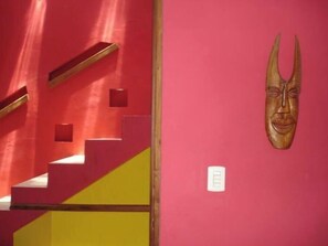 Eine Treppe mit roten Wänden und einem hölzernen Geländer.