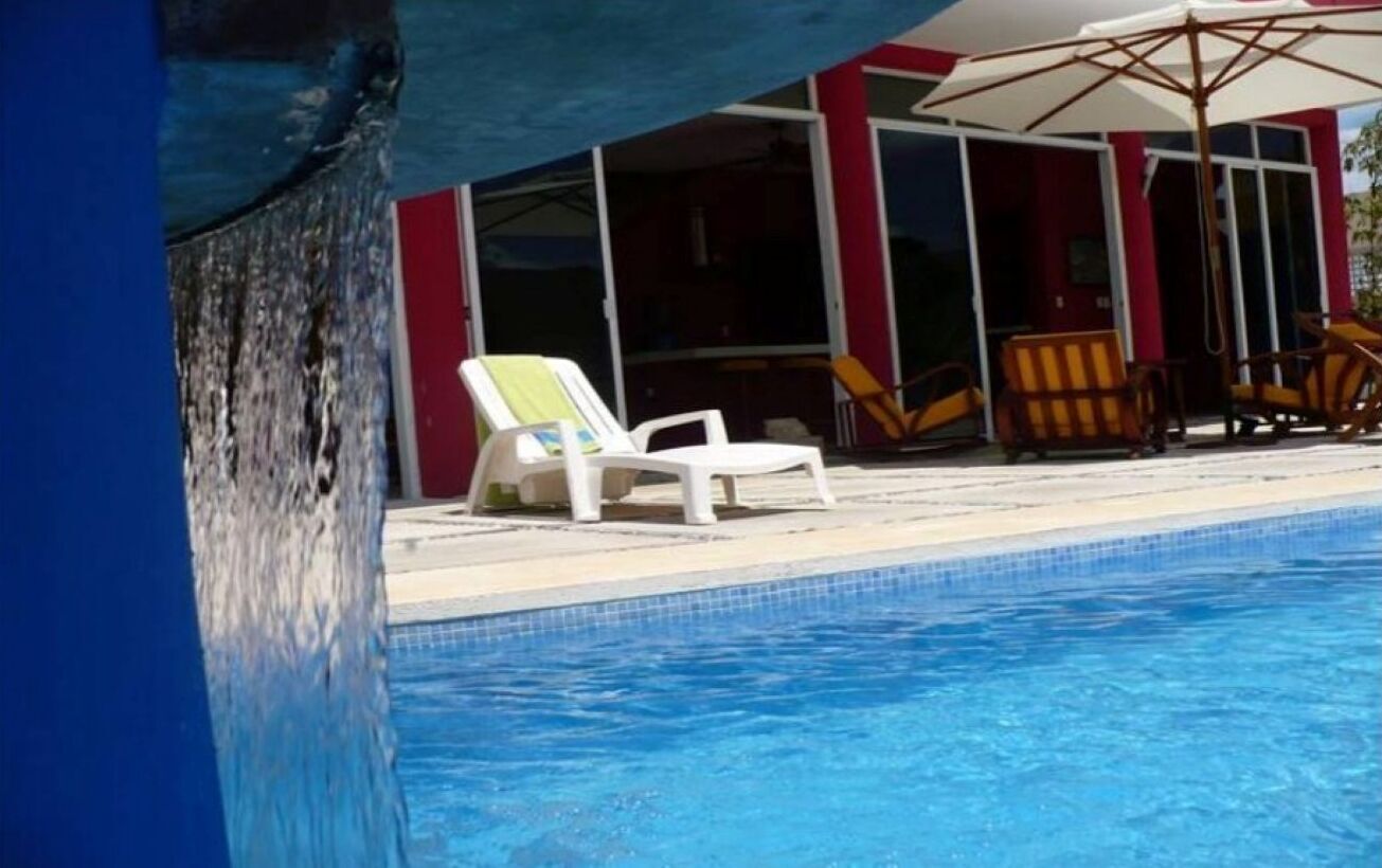 A swimming pool with lounge chairs and umbrellas.