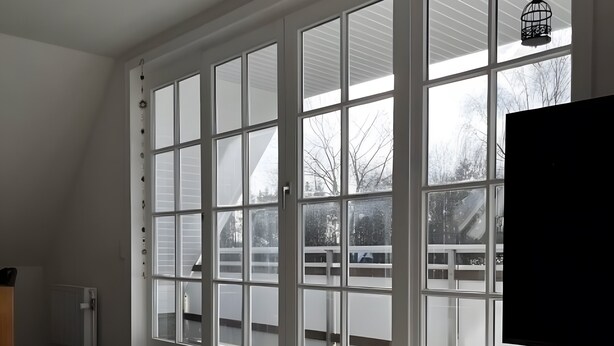 Una habitación con ventanas amplias, un radiador y un televisor.