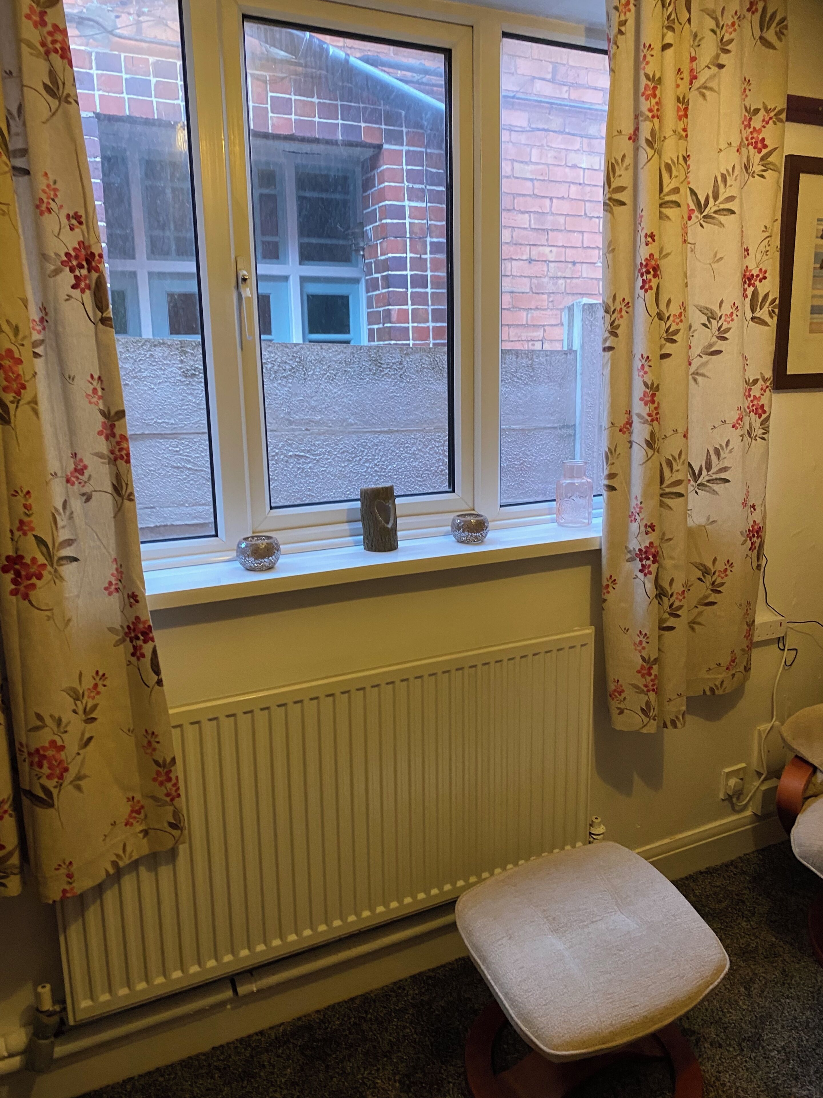 A room with a window, radiator, and a bench.