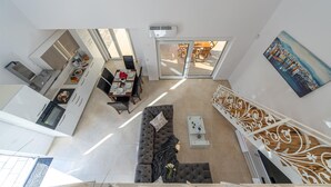 Un apartamento moderno con comedor, sala de estar con sofá y una escalera.