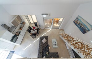 A modern apartment with a dining area, a living room with a sofa, and a staircase. - Lovely home in Bilice (Bilice)