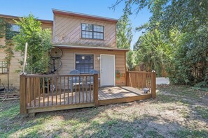 Een houten blokhut met een terras, een deur en een raam.