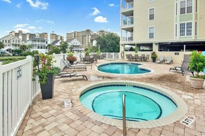 A rooftop pool area with two circular pools, lounge chairs, and potted plants. - Welcome to Far Far Away at Ocean Marsh! (North Myrtle Beach)