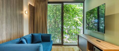 Departamento Deluxe, 1 cama King size y sofá cama, vista a la ciudad | Área de sala de estar | Smart TV de 55 pulgadas con canales digitales