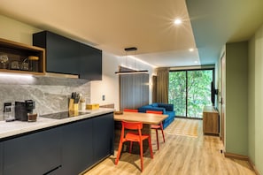Una cocina moderna con comedor, un sofá y vistas a zonas verdes.