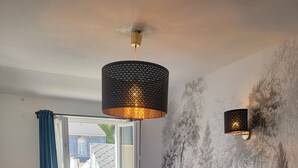 A hotel room with two beds, a patterned wall, a ceiling light, and a view through an open window. - Triple Bright Room - Centre & Château (Lourdes)