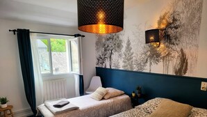 A hotel room with two beds, a large window, a wall mural, and a hanging lamp. - Triple Bright Room - Centre & Château (Lourdes)