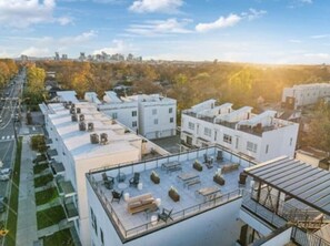 Eine Dachterrasse mit Sitzgelegenheiten im Freien und Blick auf die Stadtlandschaft.