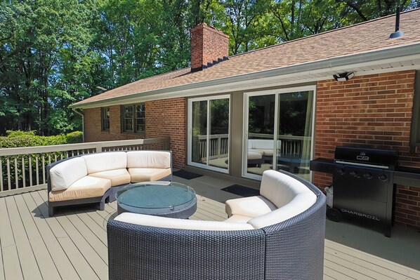 An outdoor patio with a wicker sofa, a glass-top coffee table, and a barbecue grill. - Lakefront 5BR Retreat w/ Private Dock  —Boat Ramp Across Street — Sleeps 14+ (Clarksville)