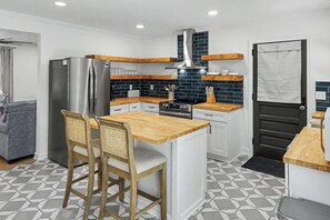 A compact kitchen with a central island, a refrigerator, and a stove. - Lakefront 5BR Retreat w/ Private Dock  —Boat Ramp Across Street — Sleeps 14+ (Clarksville)