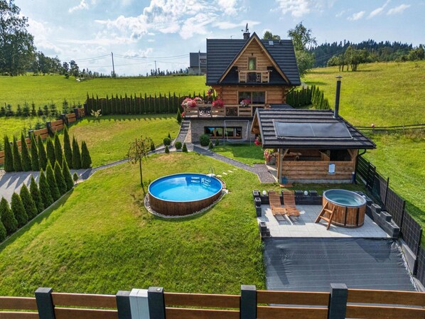 A wooden house with a swimming pool, a hot tub, and a fenced yard. - Luxury Holiday Villa, Pool, Sauna, Jacuzzi (Nowy Targ)