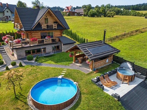 A wooden house with a swimming pool, hot tub, and outdoor seating area. - Luxury Holiday Villa, Pool, Sauna, Jacuzzi (Nowy Targ)