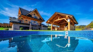 A wooden cabin with a swimming pool, stone walls, and a clear blue sky. - Luxury Holiday Villa, Pool, Sauna, Jacuzzi (Nowy Targ)