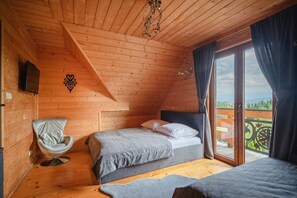 A wooden cabin bedroom with a loft bed, a chair, and a balcony with a view. - Luxury Holiday Villa, Pool, Sauna, Jacuzzi (Nowy Targ)