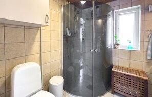 A bathroom with a glass-enclosed shower, a toilet, a trash bin, and a window with a plant. - Amazing home in Glesborg with WiFi (Glesborg)
