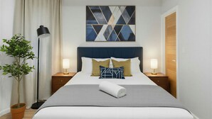 A neatly arranged hotel room with a bed, bedside tables, a potted plant, and a geometric wall art piece. - Charming 2-bedroom Apartment with AC in Yonkers (Yonkers)