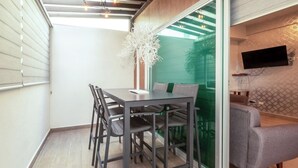 A modern room with a dining table, chairs, a sofa, a TV, and a decorative plant. - Apartment for 6 on the first floor with pool (Mazatlan)