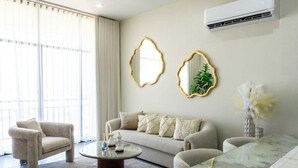 Una sala de estar con sofá, sillón, mesa de centro y espejos decorativos.