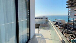 A balcony with a view of the ocean and adjacent buildings. - Ocean view 1 block from the malecon beach (Mazatlan)