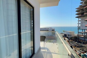 Ein Balkon mit Blick auf das Meer und angrenzende Gebäude.