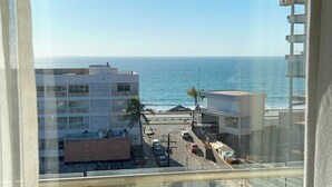 A view of a coastal area with buildings, a road, and a beach. - Ocean view 1 block from the malecon beach (Mazatlan)