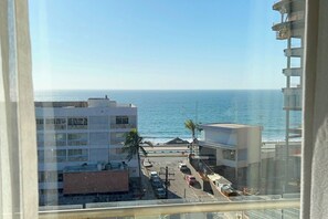 Blick auf eine Küstenlandschaft mit Gebäuden, einer Straße und einem Strand.