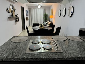 A modern kitchen with a granite countertop, four burners, and a built-in stove. - Beautiful apartment steps from the beach (Mazatlan)