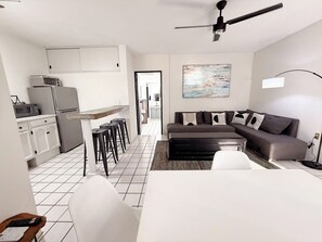 Eine moderne Wohnung mit Küche, Essbereich und Wohnzimmer.