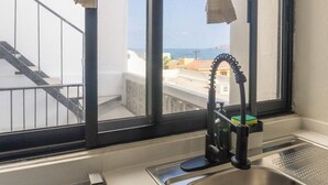 Cucina con lavello, finestra e vista sul mare.