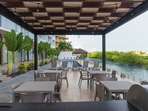 Un'area esterna riparata con piscina, sedie a sdraio e tavoli.
