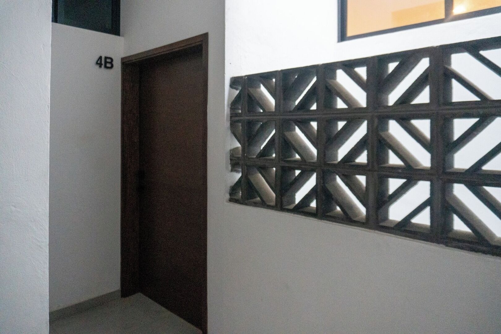 A hallway with a door marked '4B' and a decorative metal partition.
