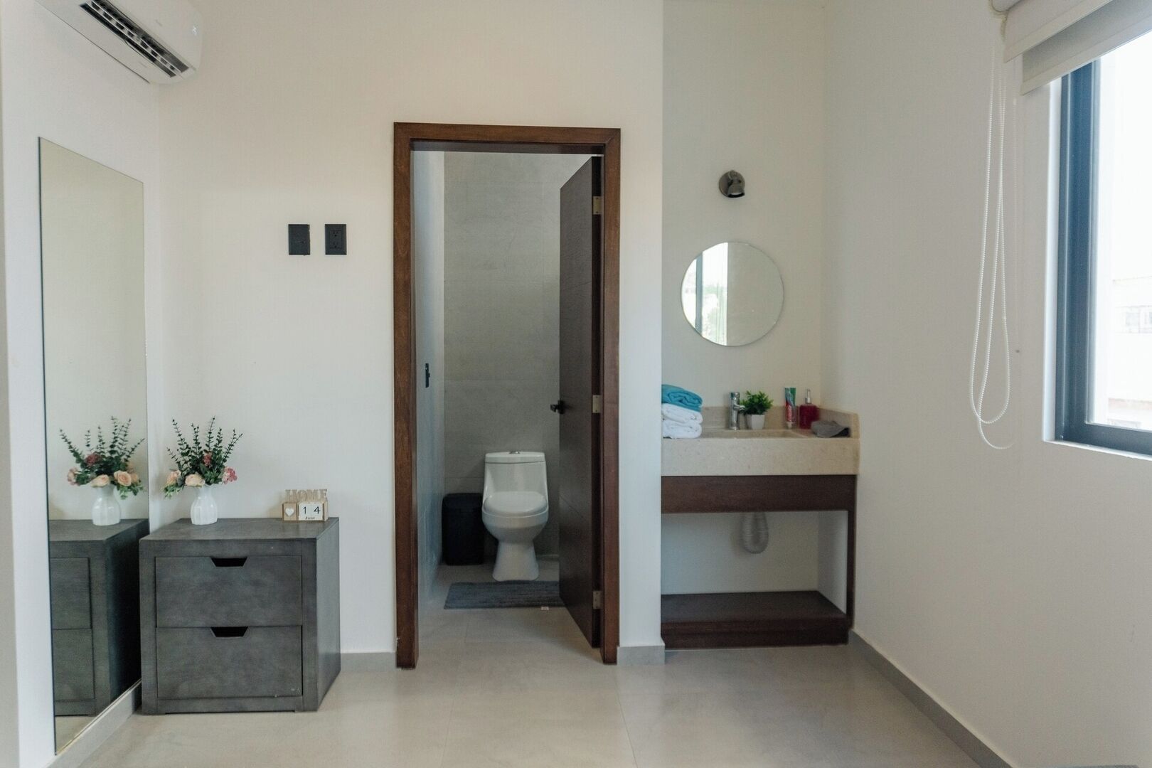 Une salle de bain comprenant des toilettes, un lavabo, un miroir et un espace douche.